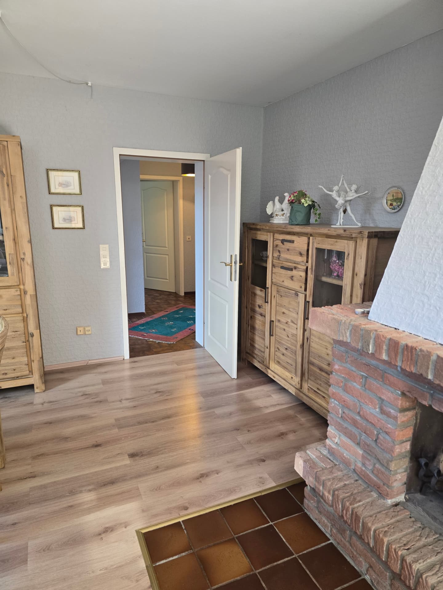 Wohnbereich mit Schrank, Durchgang zum Flur und gemauertem Kamin