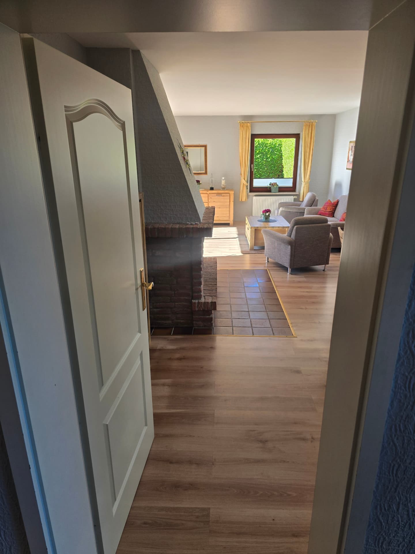 Blick durch die Tür zum Wohnbereich und Kamin