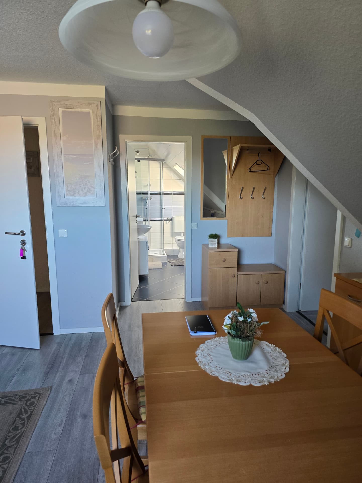 Blick über den Esstisch zur Garderobe und ins Badezimmer in der Muscheln Wohnung