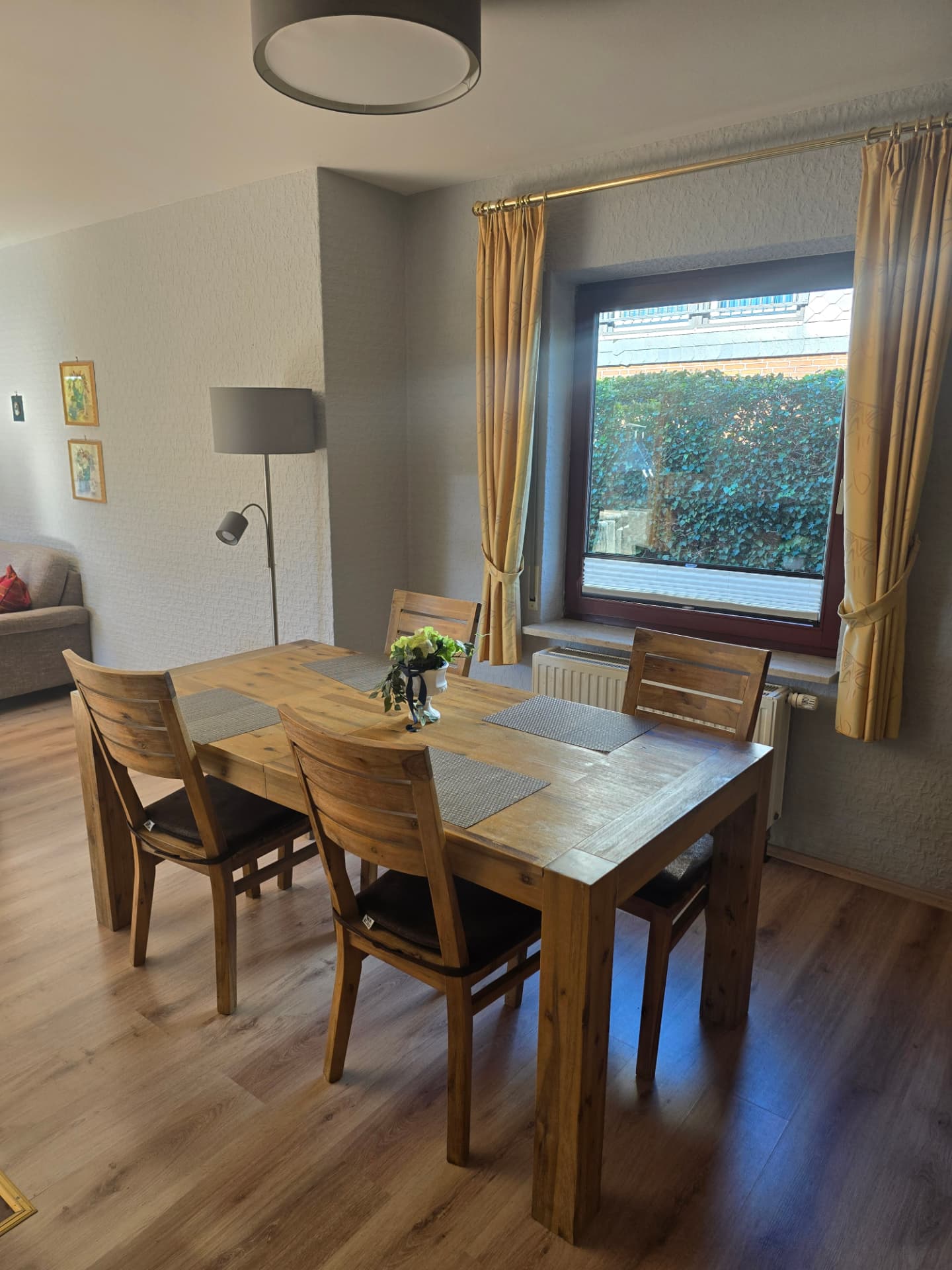 Heller Essbereich mit Holztisch und Vorhängen