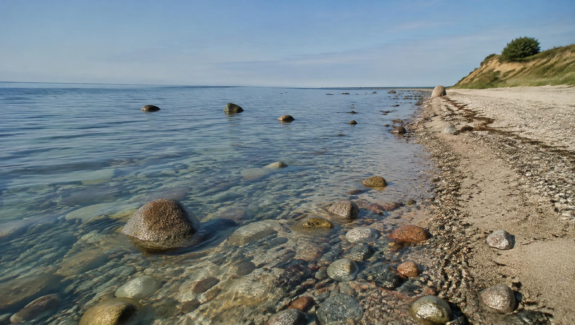 Klares Ostseewasser mit runden Steinen am Naturstrand